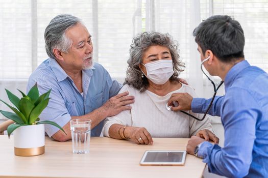 Doctor using stethoscope for auscultate Asian grandparent patient in house, service Life insurance at home, healthcare with Long live and Elderly society, Prevent epidemic concept