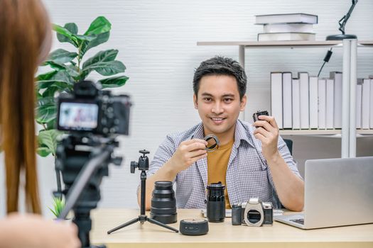 Asian Vlogger man satisfied the camera lens each media, Video Cameraman taking video and live with laptop, sharing knowledge to audience via camera by social media channel,vlog and Influencer concept