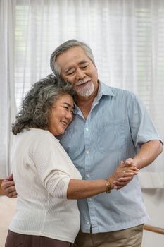 Asian couple Grandparent dancing and hugging together with happy feeling in house, romantic and lover with valentine or anniversary, Long live and Elderly society, Warm family and happiness concept