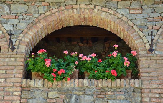 Beautiful pink geranium planters on brick ledge