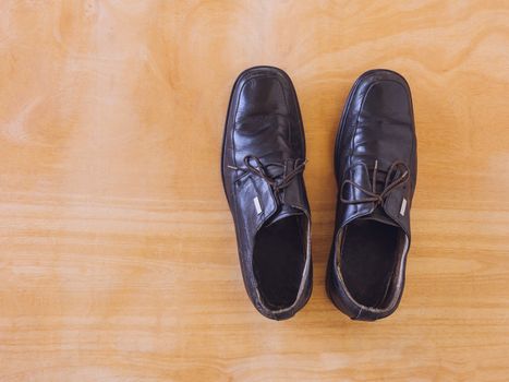 Top view of old shoes on wooden table