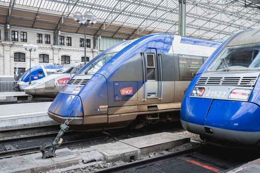 Tours, France - February 8, 2020: train at platform where people walk inside Tours train station in the city center on a winter day