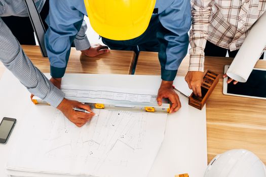 Team of engineers discussing architecture plan sketch at the construction site.