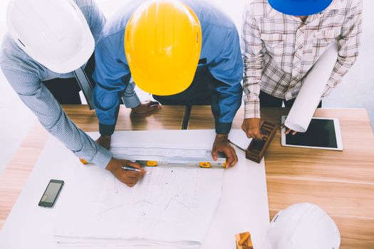 Team of engineers discussing architecture plan sketch at the construction site.