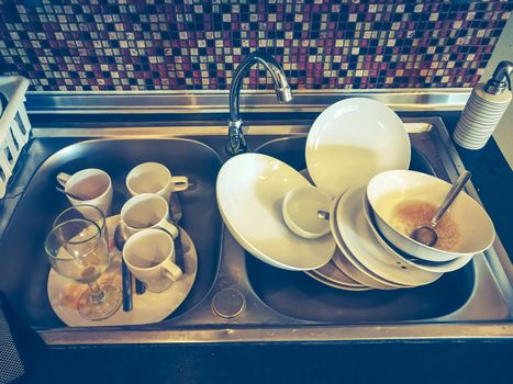 Many kitchenwares for clean in a sink.