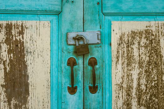 Metal lock on a old wooden door outside.