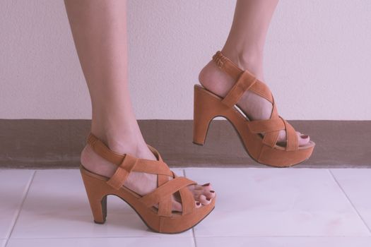 Close up of female lags with high heels shoes.