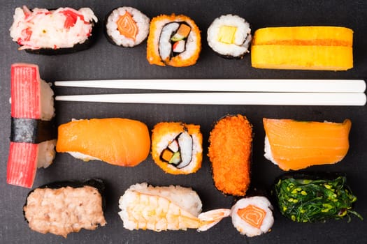 Top view of Sushi set and chopsticks on black background, Japanese food.