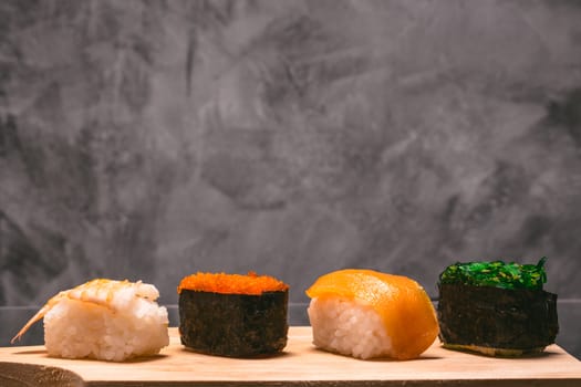 Sushi set on wooden plate on gray grunge background, Japanese food.