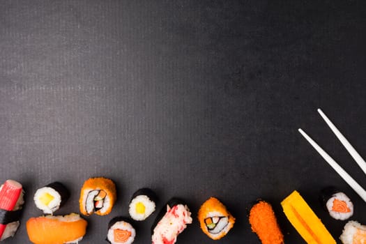 Top view of Sushi set and chopsticks on black background, Japanese food. Free space for text