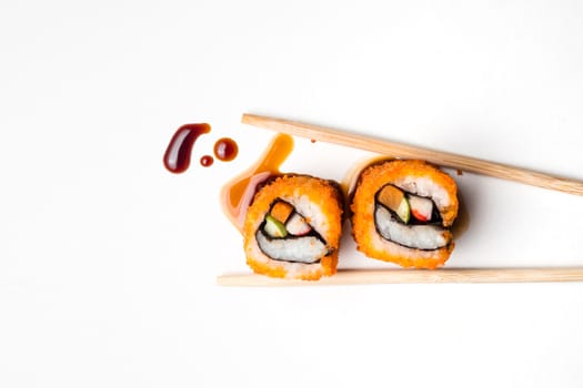 Sushi, japanese food, california roll with chopsticks and sauce on white background.
