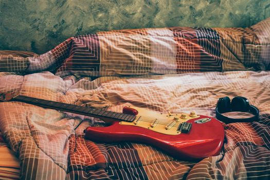Electric guitar and headphones in bedroom, Films grain filter.