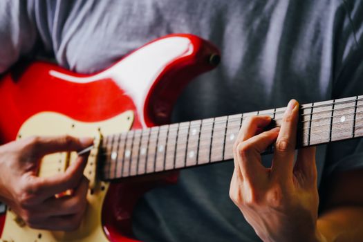 Close up of male hands playing electric guitar. Selective focus