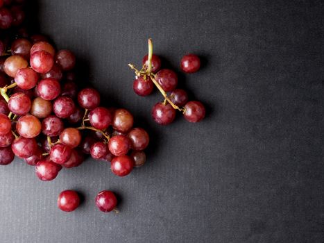 Top view of Red grapes on a black background. Free space for text