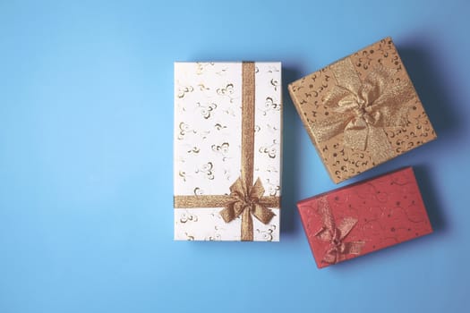Top view of gift boxes on blue background. Free space for text