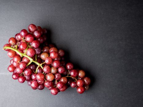 Top view of Red grapes on a black background. Free space for text