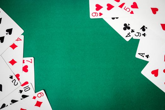 Playing cards on green background. Free space for text