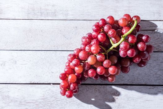 Top view of Red grapes on the wooden table. Free space for text