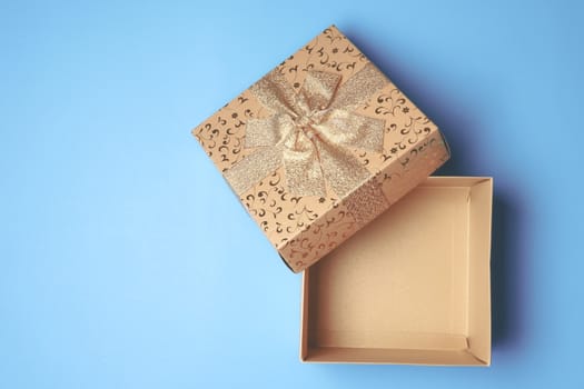 Top view of open gift box on blue background. Free space for text