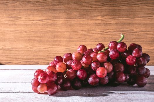 Red grapes on the wooden table. Free space for text