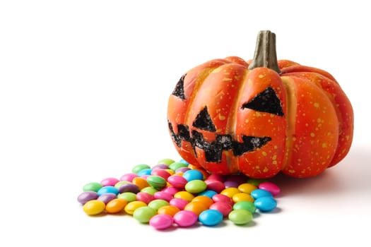 Halloween pumpkin with pile of candy on a white background.