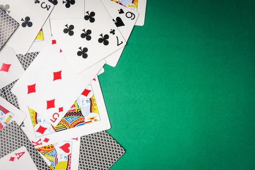 Playing cards on green background. Free space for text