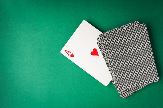 Heart ace with playing cards on green background. Free space for text