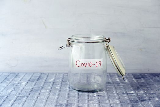 Empty glass money jar with covid19 label, financial concept.