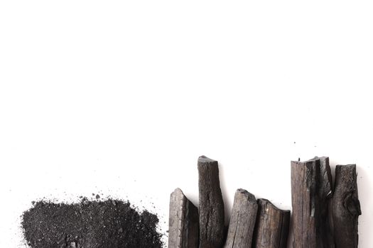 Charcoal and powder (activated carbon) on white background. Free space for text