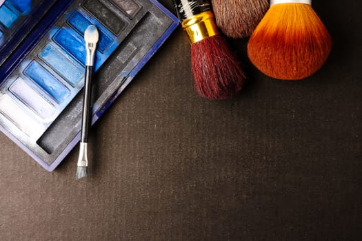 Makeup brushes and palette on black background, Free space for text.
