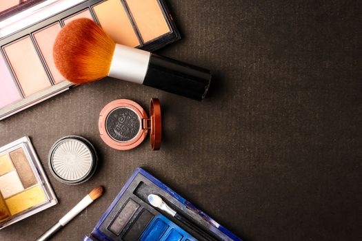 Top view of cosmetics set for makeup on a blue background. Free space for text.