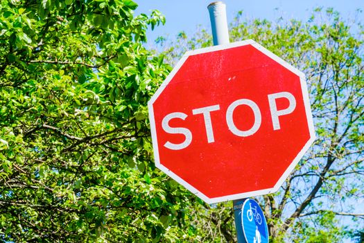 roadside red stop sign with trees in background UK