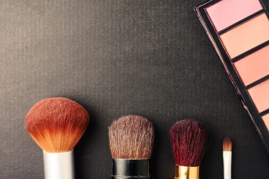Makeup brushes and palette on black background, Free space for text.