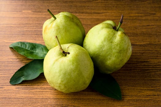 Fresh guava fruit on wooden table background.