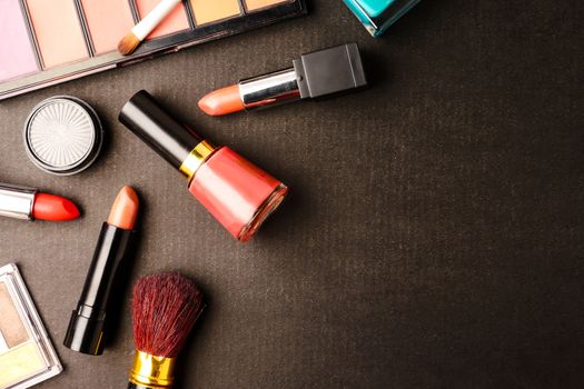 Top view of cosmetics set for makeup on a blue background. Free space for text.