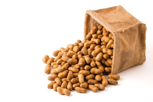 Peanuts in burlap bag on white background.