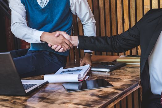 Successful business partners shaking hands, finishing up a meeting.