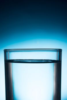 A glass of water on blue background.