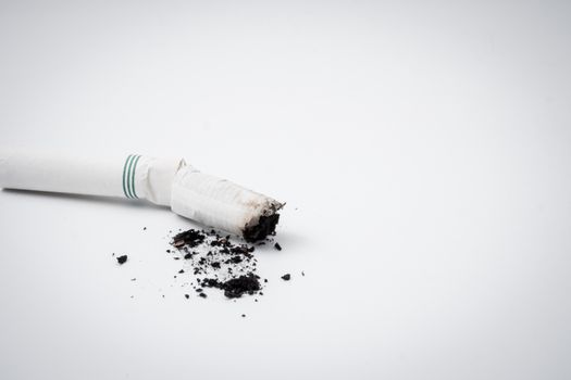 Cigarette butt with ash on a white background. Free space for text