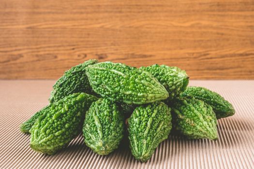 Bitter melon or bitter gourd on wooden background.