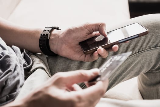 Close up of male hands using smartphone and holding credit card. Online shopping concept. selective focus