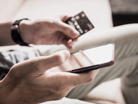 Close up of male hands using smartphone and holding credit card. Online shopping concept. selective focus