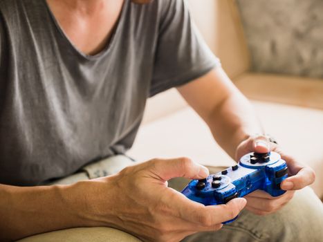 Close up of a young gamer playing the video game with a joystick.