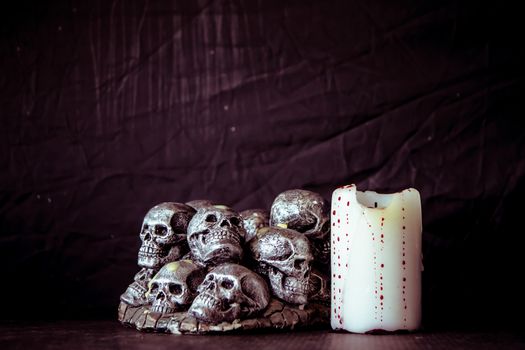 Skulls and candle  on a black background. Vintage tone.