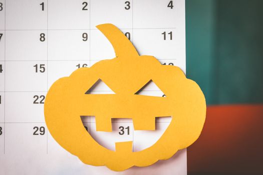 Halloween holiday concept, Pumpkin cut paper with calendar.