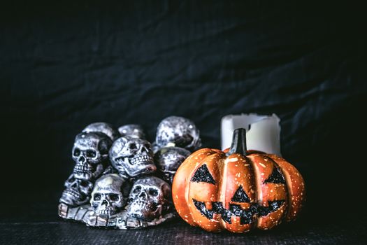 Halloween pumpkin with skulls and candle  on a black background.