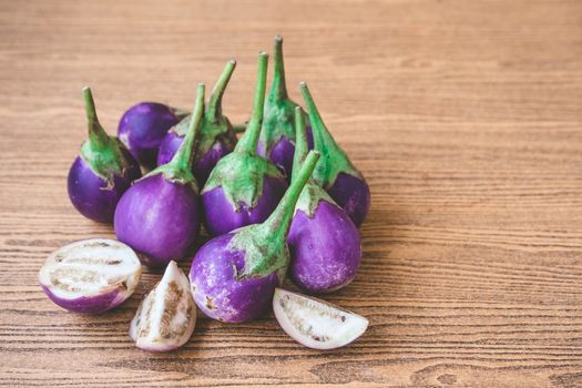 Fresh Purple eggplants on wooden table. Free space for text