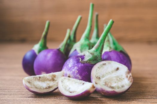 Fresh Purple eggplants on wooden table.