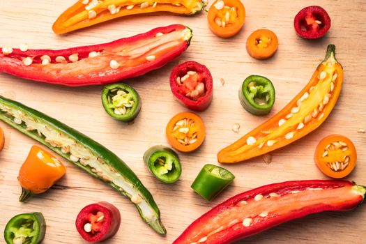 Colorful mix of chili pappers on wooden background.