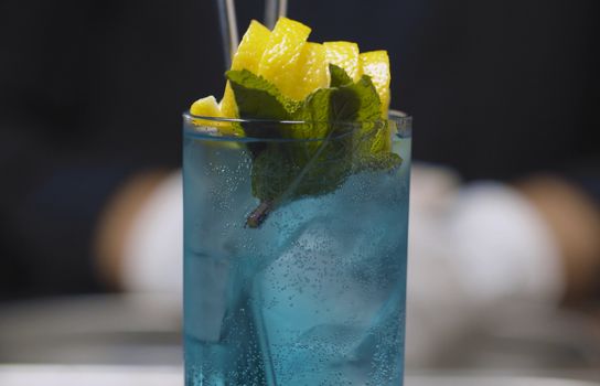 Close up glass of Blue Lagoon Cocktail on the table. Ready long drink. Bar drinks series